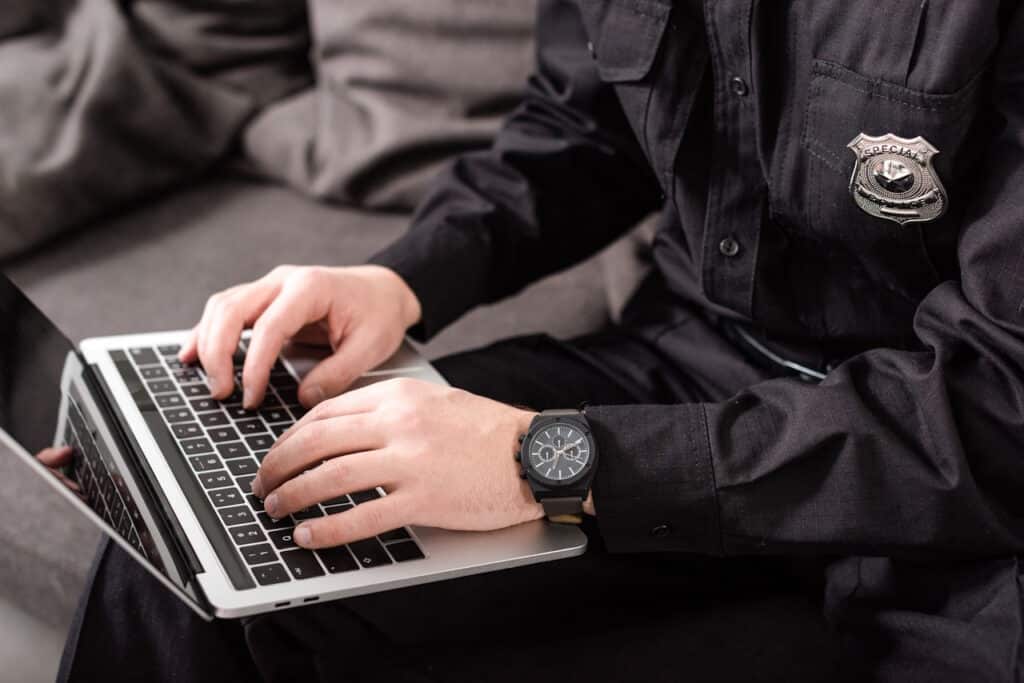 policeman typing on laptop