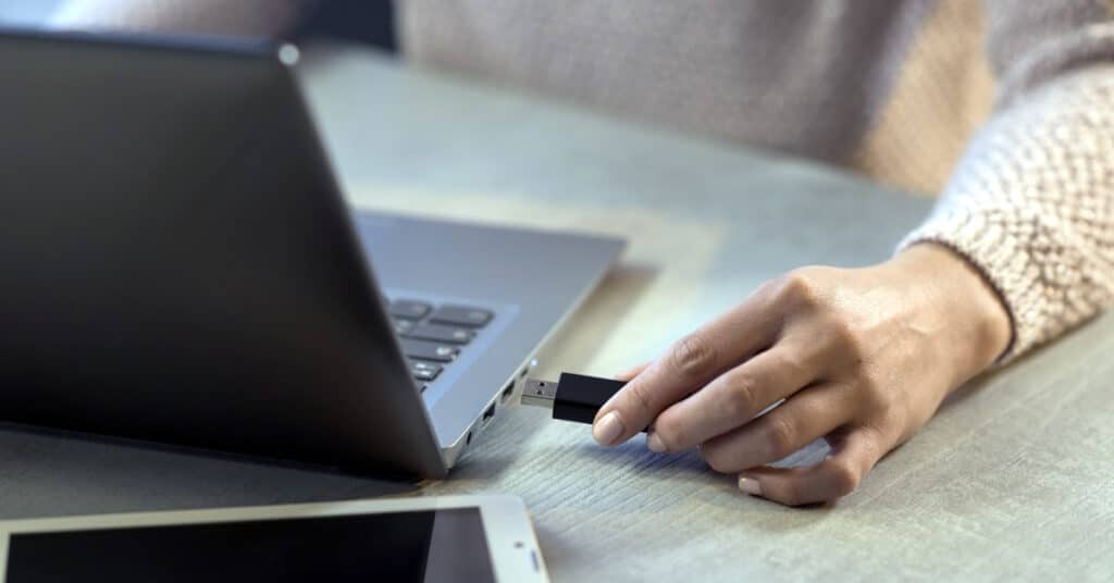 A person using a hardware security key on a laptop.